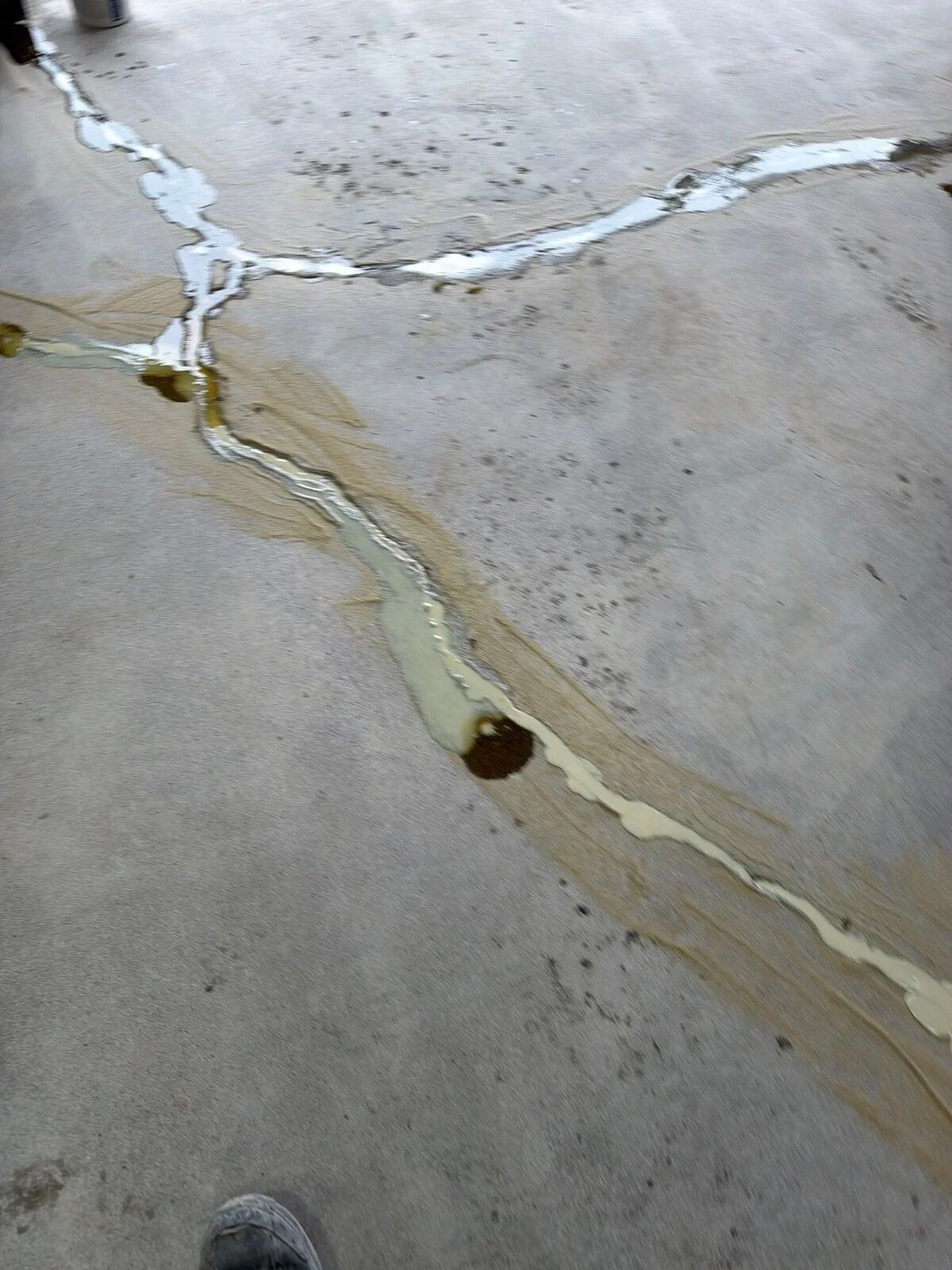 Cracks in concrete cut open and filled with 2-part repair material