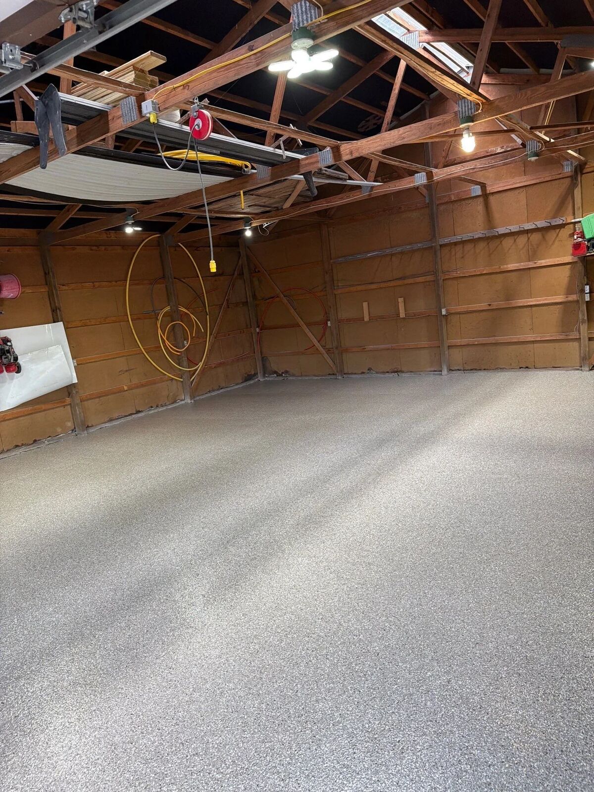 Sunlight across a finished gray flake floor beside a wall