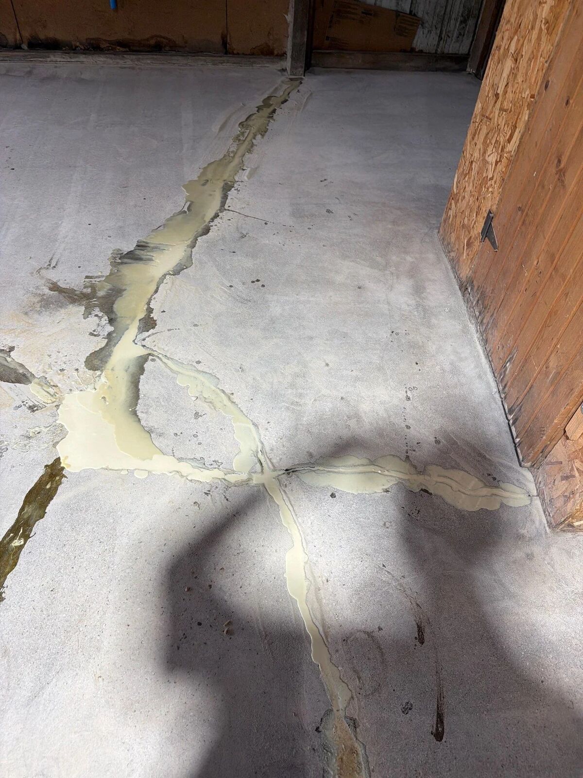 Filled crack in concrete near a wood wall during prep