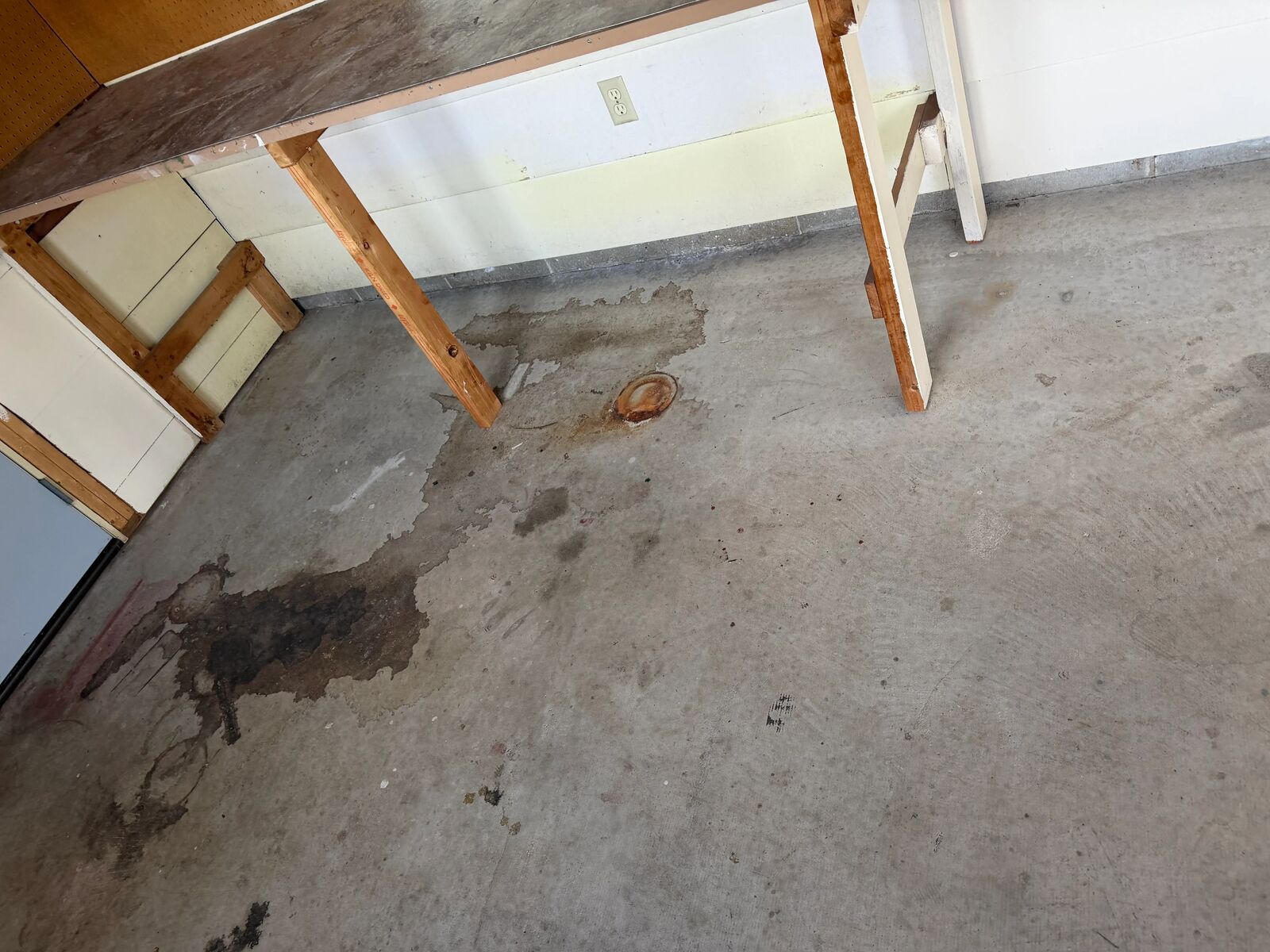 Bare concrete garage slab with oil stains before preparation